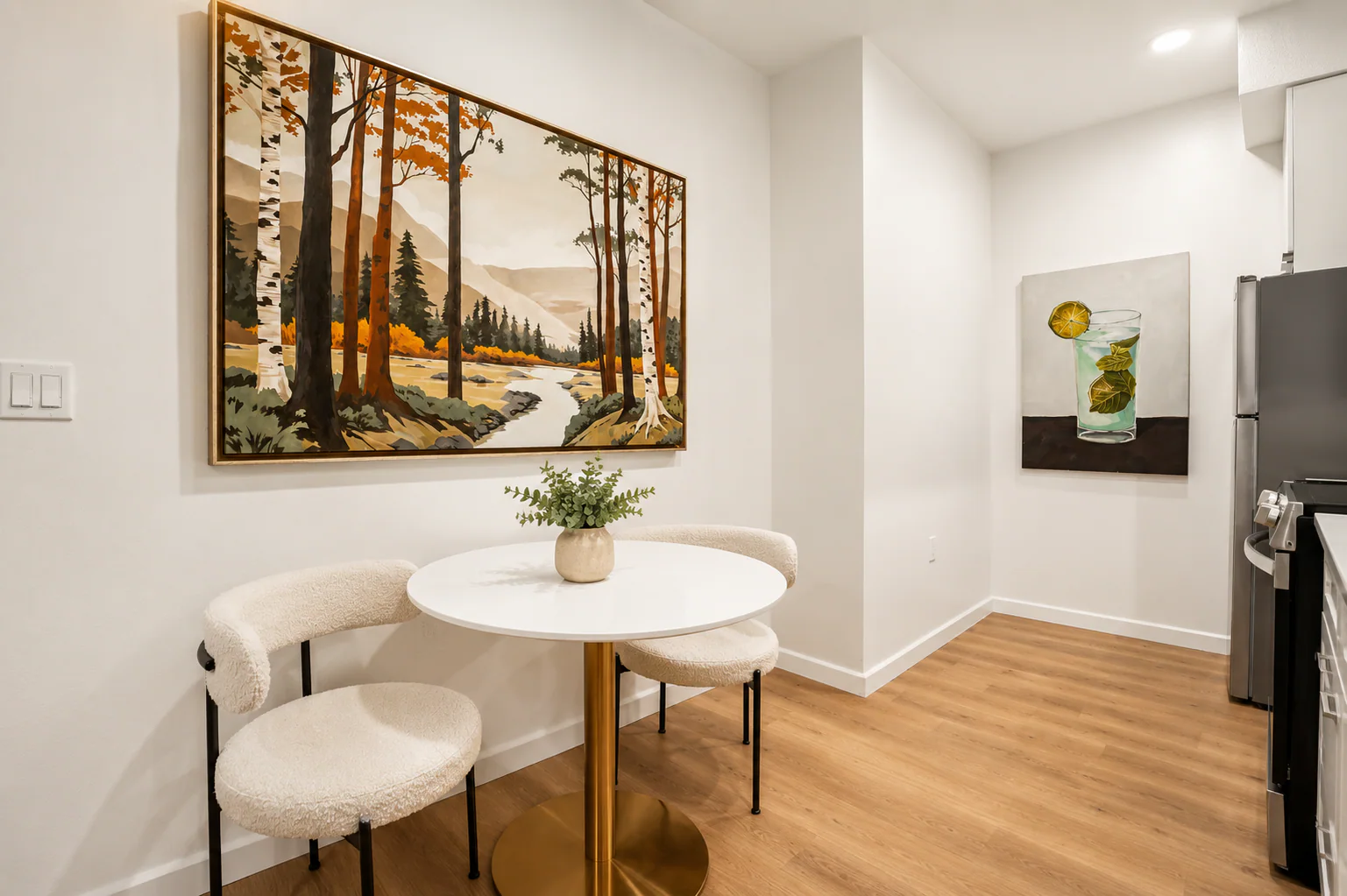 Dining area with forest landscape art and open kitchen view